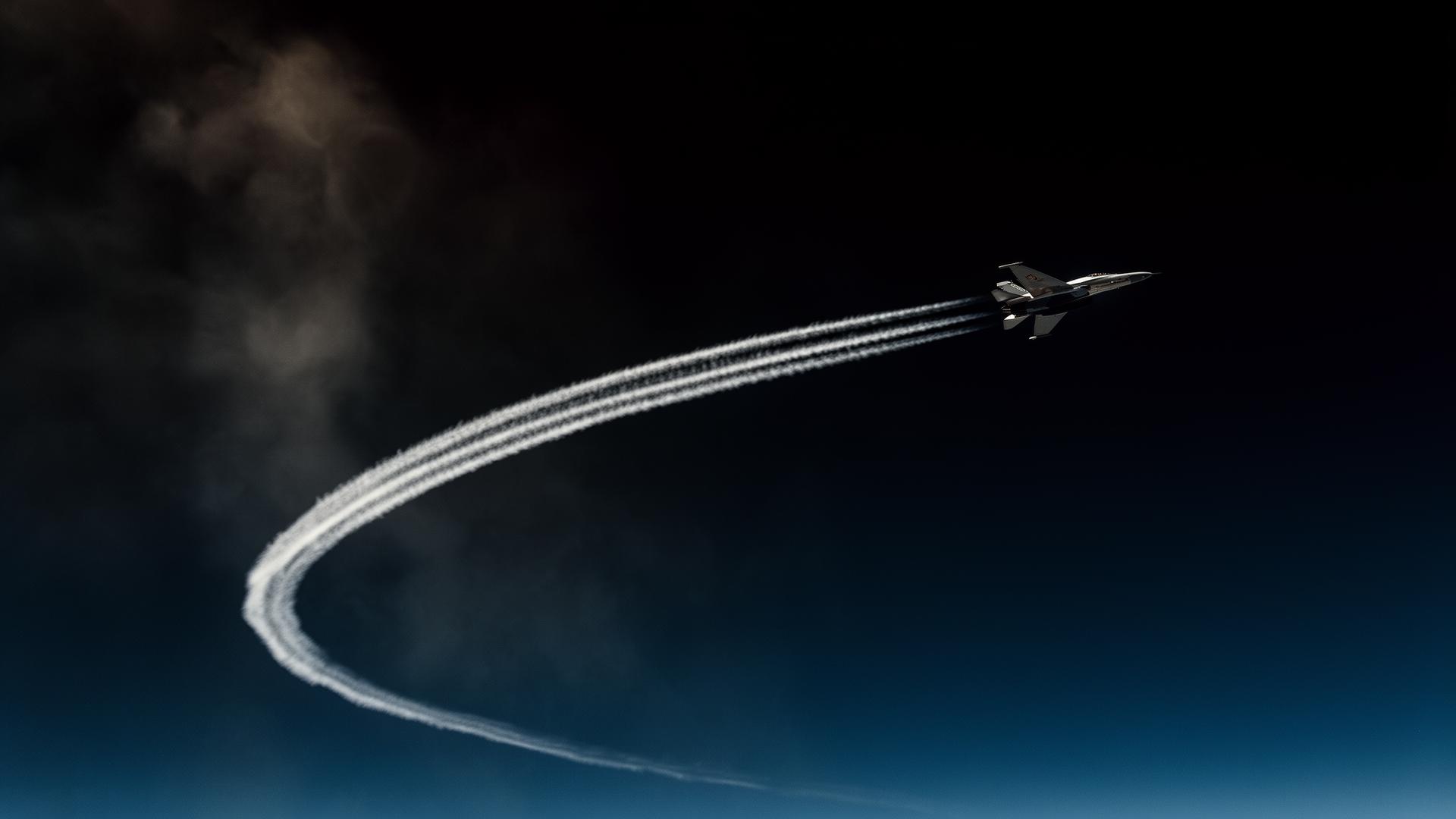 High-altitude aircraft contrail across deep sky